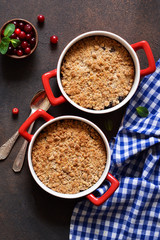 Crumble with cranberries and other berries, nuts on the kitchen table. View from above.