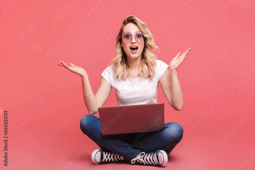 Sticker portrait of modern blond woman 20s wearing vintage sunglasses holding laptop while sitting on floor