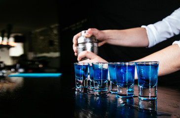 Bartender pouring blue shots