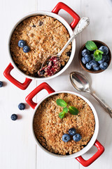 Crumble with blueberries on a white kitchen table. View from above.