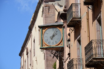 Old watch on a church facade in Bosa