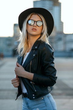 Street shot of young glamor woman wearing sunglasses and black hat