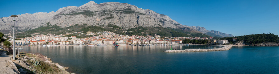 Fototapeta na wymiar City of Makarska and calm blue sea panorama