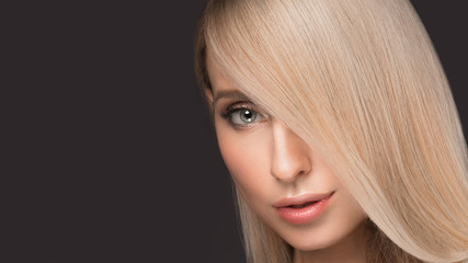 Naklejka premium Beautiful blond girl with a perfectly smooth hair, and classic make-up. Beauty face.