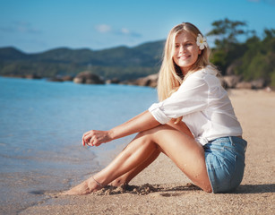 Fototapeta na wymiar young happy blonde beautiful girl on tropical sea background, smiling happy girl outdoor portrait