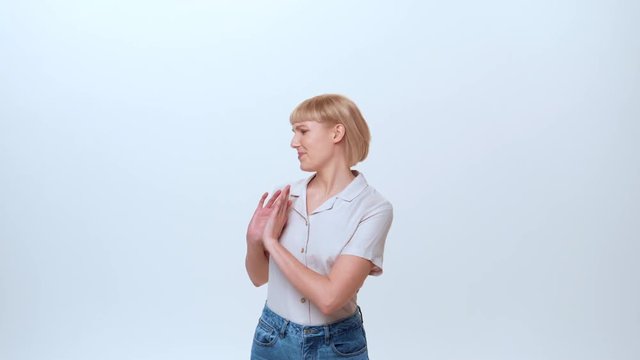 A young casually dressed female with blue eyes and blonde hair is showing the emotion of being upset, irritated and not satisfied. She is refusing an offer of selected MLM products.