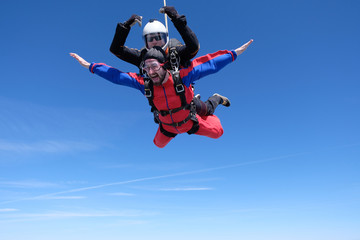Fototapeta na wymiar Tandem skydiving. Two happy men are in the sky.