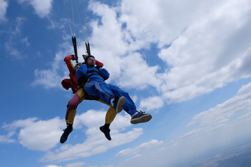 Skydiving. Tandem jump. Happy passenger and his instructor.