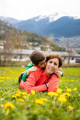 Fototapeta premium Mother and son lying down on a green field
