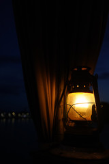 candles in the lantern in the dark with the background of a curtain and the bokeh of the light from the city