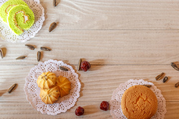Cake Roll Cookie Cupcake Sunflower Seed and Gooseberry on White Wooden Table