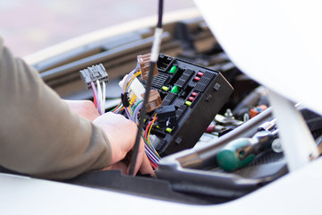 Mechanic checking the car fuse of electric car.