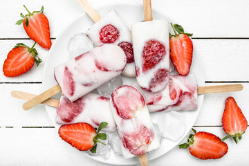 Fresh strawberry popsicles with yogurt and fruits, ice cream frozen on sticks