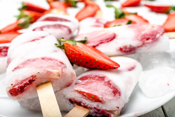 Natural juicy strawberry popsicles with yogurt. Refreshing ice pops, closeup
