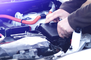 Mechanic checking the car fuse of electric car.
