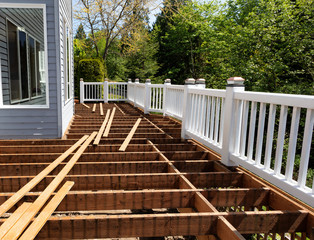 Outdoor wooden cedar deck being remodeled down to structure