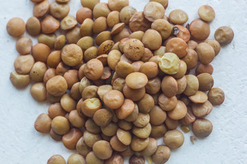 A heap of dried black soybean seeds close-up on a white table background. bean sowing season. close up top view copy space