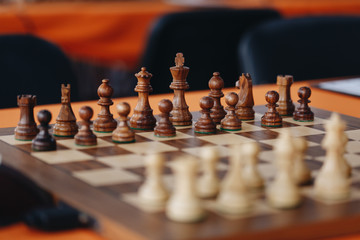 Chess pieces on a boart ready to play a game. Wood pieces of a game of chess on a board