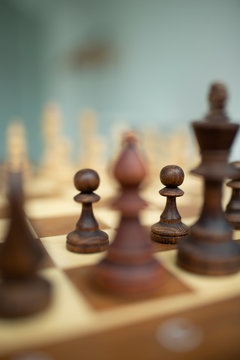 Wooden chess pieces on a chessboard, leadership concept