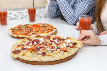 Friends in cafe eating pizza and posing for camera