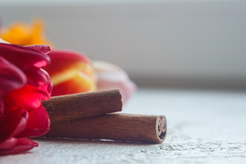 twisted cinnamon sticks close-up on a white table background. seasoning and flowers close up. copy space. spice