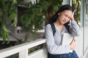 portrait of stressed, serious, worried, upset asian woman college student thinking in city campus environment