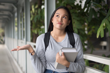 Frustrated Asian college woman student shrugging with bad, unsatisfied, negative problem