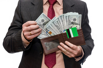 Male hands holding wallet full of dollar banknotes close up
