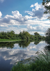 Beautiful summer landscape with pretty river and colorful trees. View of the sky with beautiful clouds. Stock photo