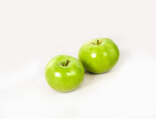 Two lovely green juicy apples on a white isolated background. Vegetarian food. Stock photo