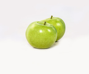 Two lovely green juicy apples on a white isolated background. Vegetarian food. Stock photo