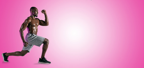 Fototapeta na wymiar Young african-american bodybuilder training over pink studio background. Muscular single male model in sportwear. Concept of sport, bodybuilding, healthy lifestyle. Ad flyer. Negative space. Collage.