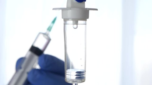 Perfusion Installation in Foreground Man Hands Using a Syringe in Background