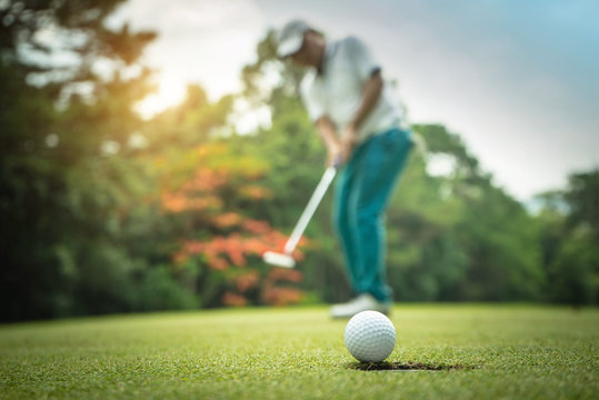 Golfer action to win after long putting golf ball on the green golf