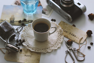A Cup of coffee is on the table, next is a retro camera