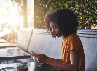 Young woman using mobile phone in cafe