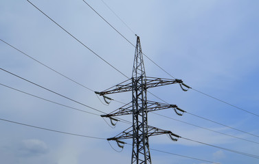 High voltage electricity transmission line on a blue sky background. Copy space for text.
