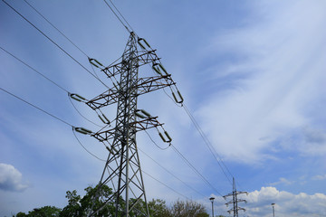 High voltage electricity transmission line on a blue sky background. Copy space for text.