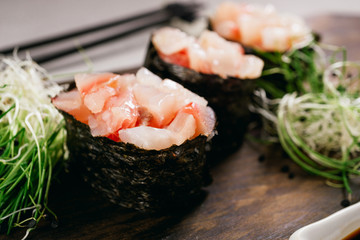 Seafood delicatessen gunkan maki sushi rolls on wooden plate. Food blog and culinary, restaurant menu