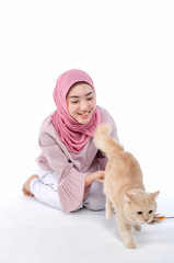 Obraz premium pretty young hijab muslimah play with her cat over white background