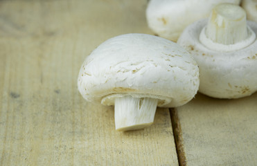 Fototapeta na wymiar Champignon mushrooms on wooden background