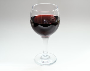 Wine in a glass on light background. Selective focus.