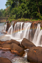 Bright rainbow over Tad Pha Suam waterfall.