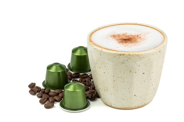 Side view of Hot cappuccino coffee in a vintage cup with aluminum capsules and roasted coffee beans isolated on white background. (Image stacking technique)