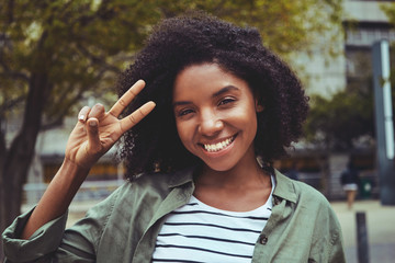 Charming young woman making peace gesture
