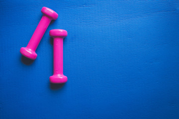 Fitness equipment dumbbells on color background. Flat lay.
