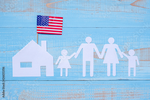 People or Family and home paper shape with  flag of the United States of America on blue wooden background. USA holiday of Veterans, Memorial, Independence and Labor Day