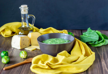 Cream soup with spinach and cheese. Healthy eating. Wooden background.