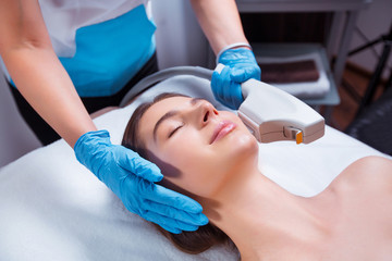 Skin care concept. Hardware cosmetology. Close up picture of attractive woman with fresh freckled...