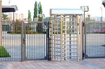 Protected entrance gate.Entrance to office through big in full human growth stainless steel turnstiles. Concept of security, lock, gates, business, dangerous.